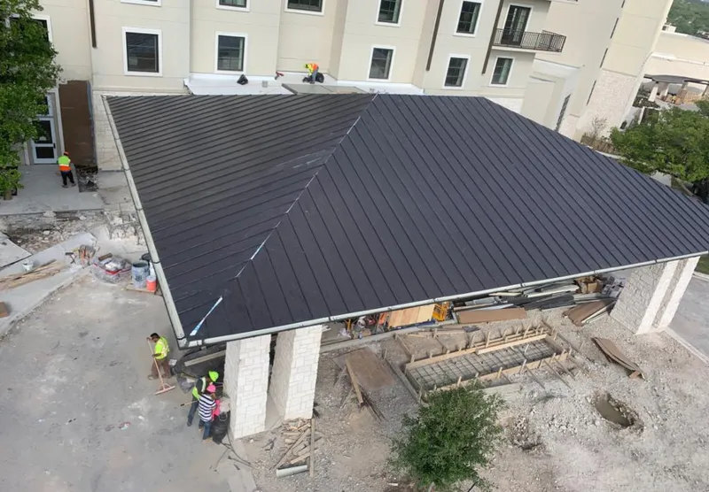 Metal roofing installation team working on a commercial building in Harvard