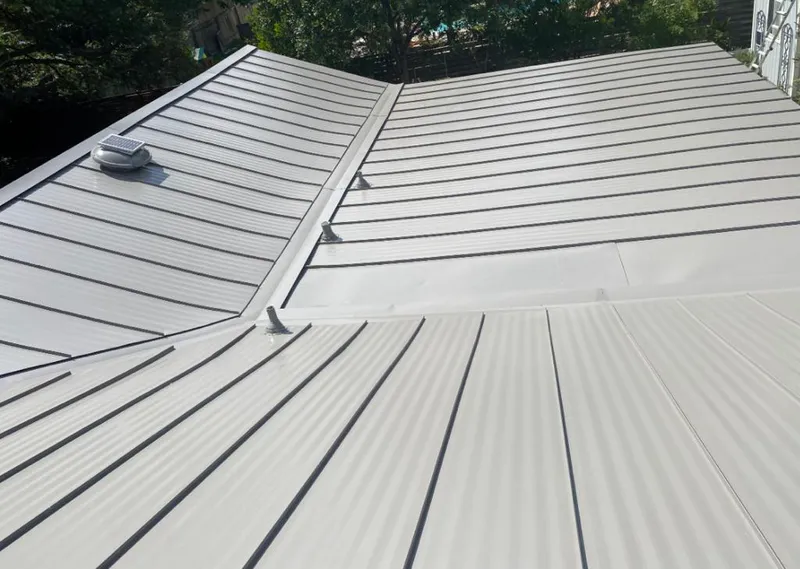 Solar attic fan installed on a metal roof for Roof Ventilation in Harvard